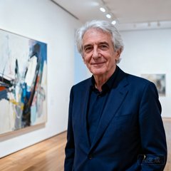 巴黎当代艺术基金会主席让·吕克·莫罗的肖像照片，一位银发长者身着深蓝色西装站在画廊中